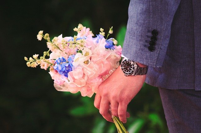 時計を付けた男性の手に花束